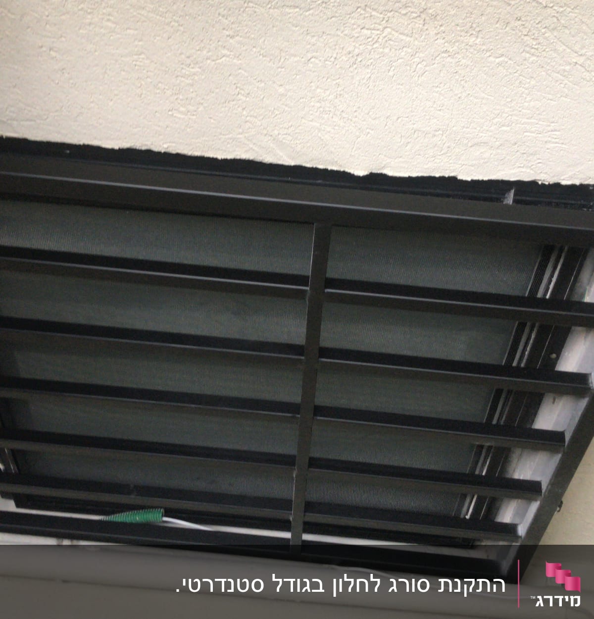 מסגרת מתכת שחורה עם סורגים על תקרה לבנה